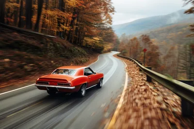 Classic Orange Muscle Car Driving On Winding Autumn Road