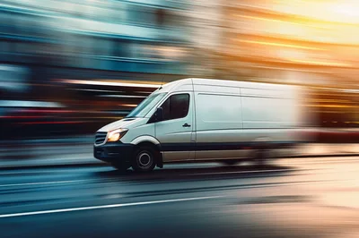 White Delivery Van Driving Fast Through City Streets