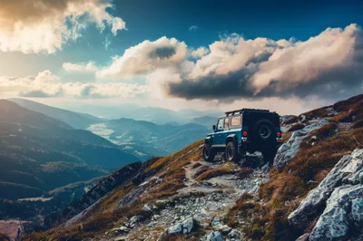 Blue Off-Road Vehicle Driving On Mountain Ridge