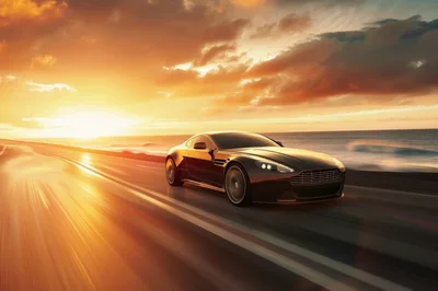 Luxury Sports Car Driving Along Coastal Highway At Sunset