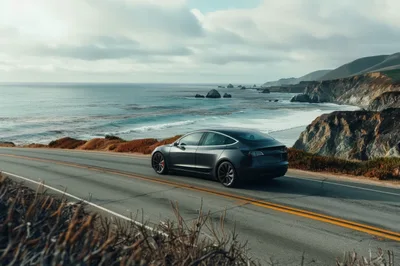 Dark Gray Tesla Model 3 Driving Along Coastal Highway
