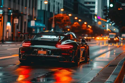 Black Sports Car Driving Through City Street At Night