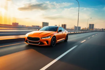 Orange Sports Sedan Driving Fast on City Bridge
