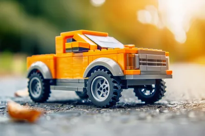 Orange Toy Pickup Truck on Asphalt Road