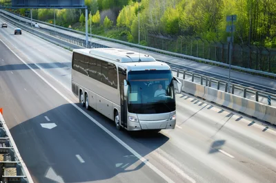 Silver Tour Bus Driving on Highway