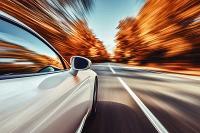 White Sports Car Driving Fast Through Autumn Forest
