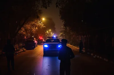 Police Officers Patrolling Street at Night with Emergency Lights