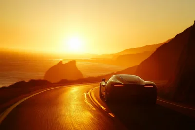 Supercar Driving Along Coastal Highway At Sunset