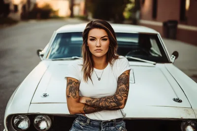 Tattooed Woman Leaning Against A Vintage White Muscle Car
