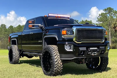Custom Black Lifted Pickup Truck Parked In Field