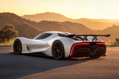 Futuristic White Supercar Parked On Mountain Road At Sunset