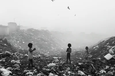 Children Standing Amidst A Vast Garbage Dump