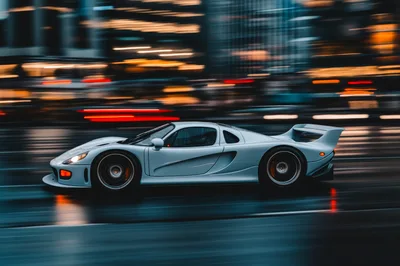 Silver Supercar Driving Fast Through City Streets