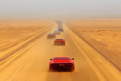 Convoy of Vintage Sports Cars Driving Through Desert