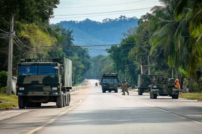 Military Convoy Traveling Along A Rural Road
