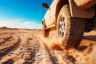 Off-Road Vehicle Driving Through Sandy Desert Landscape