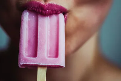 Close Up Of Woman Eating Pink Popsicle
