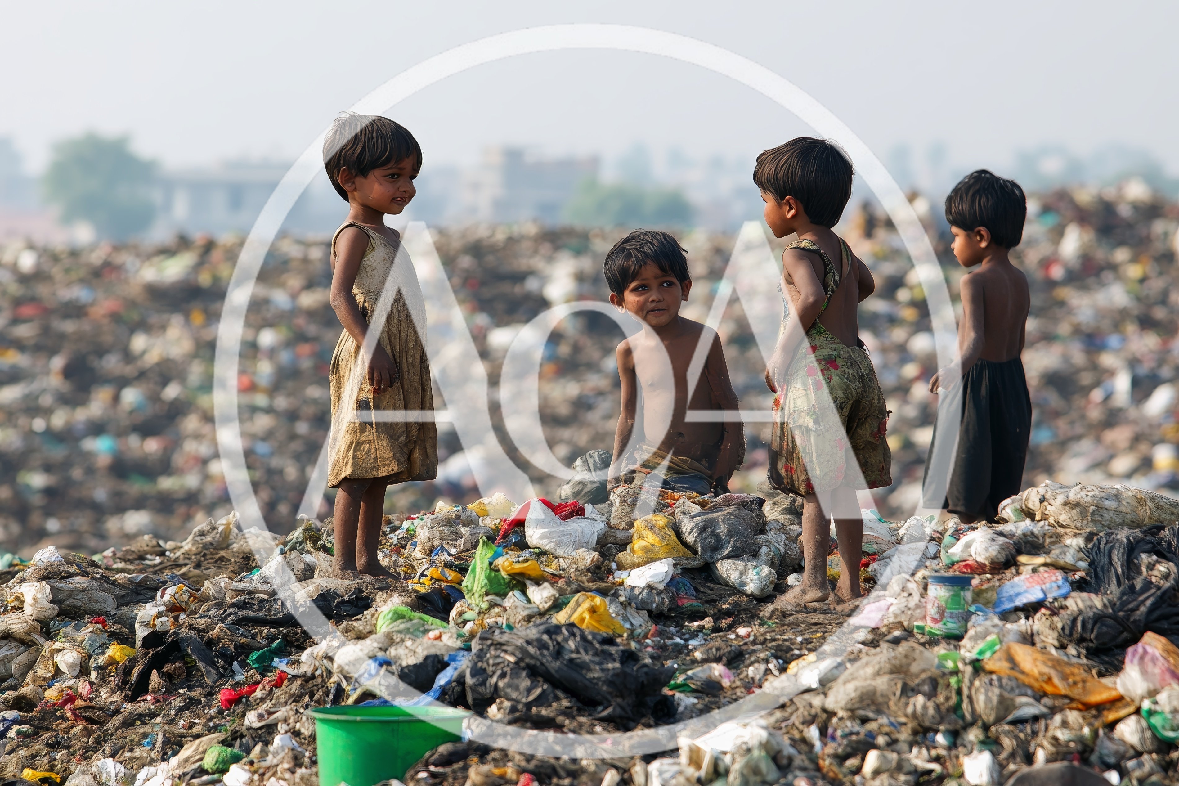 Children Standing Amidst A Large Garbage Landfill