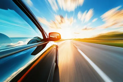 Black Car Driving Fast On A Highway At Sunset