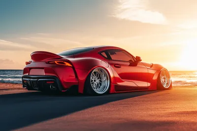 Modified Red Toyota Supra On A Beach At Sunset