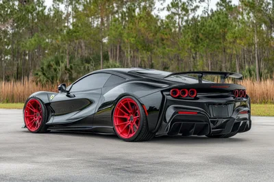 Black Ferrari Supercar With Red Wheels Parked Outdoors