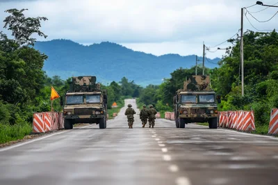 Military Soldiers Walking Between Two Tactical Trucks