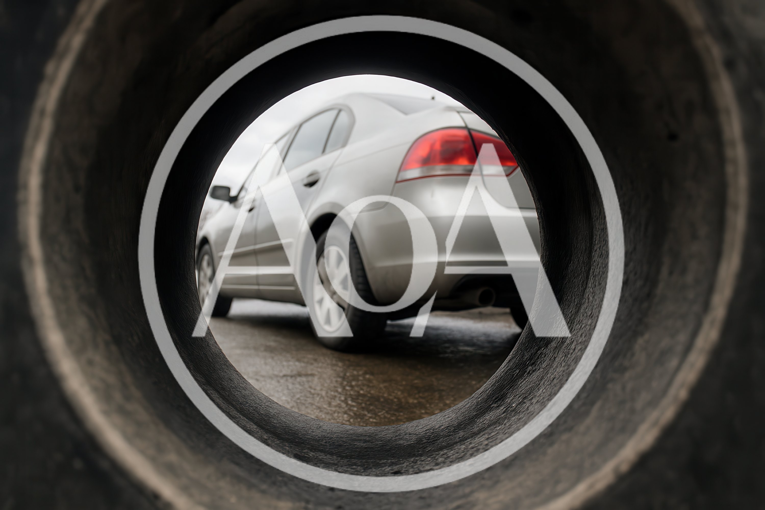 Silver Sedan Seen Through A Large Tire