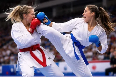 Female Karate Athletes Competing In A Kumite Match