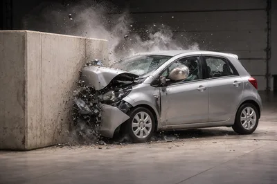Silver Hatchback Car Crashing Into Concrete Wall