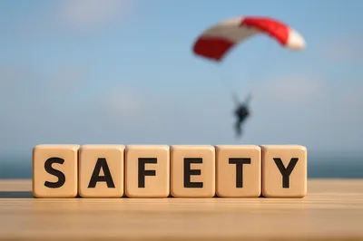 Wooden Blocks Spelling Safety With Paraglider In Background