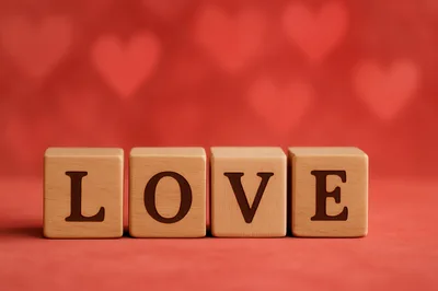 Wooden Blocks Spelling Love On Red Background