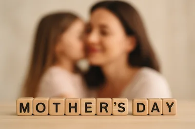 Wooden Blocks Spelling Mothers Day With Blurred Mother And Daughter