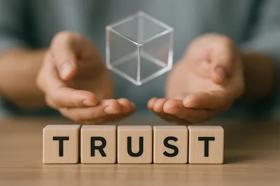 Hands Holding A Floating Transparent Cube Above Trust Blocks