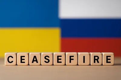 Wooden Blocks Spelling Ceasefire Against Ukrainian and Russian Flags