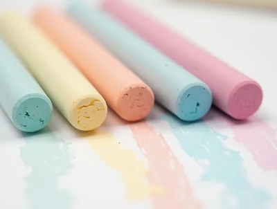 Pastel Colored Chalk Sticks Arranged On White Paper