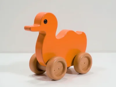 Orange Wooden Duck Toy On Wheels