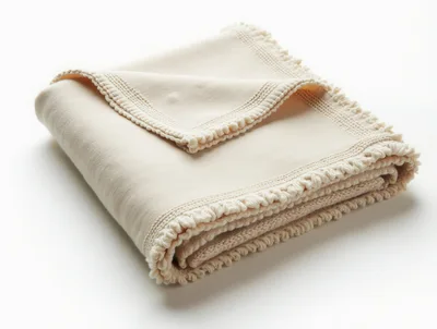 Folded Cream Colored Throw Blanket With Decorative Fringe