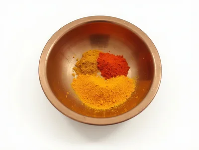 Three Piles Of Spices In A Copper Bowl