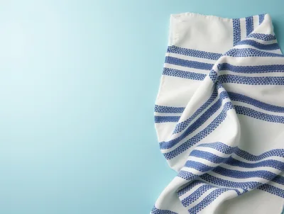 White Kitchen Towel With Blue Stripes On Light Blue Background