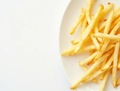 Golden Crispy French Fries On A White Plate