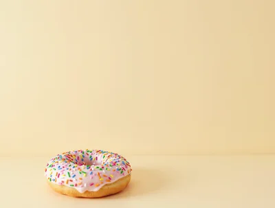 Single Pink Frosted Donut With Colorful Sprinkles
