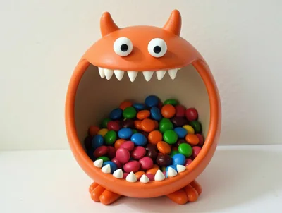 Orange Monster Candy Bowl Filled With Colorful Chocolate Candies