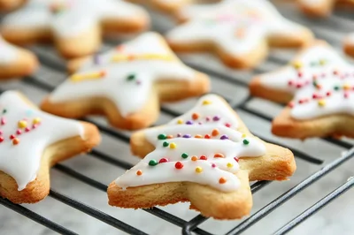 Star Shaped Christmas Cookies With White Icing And Sprinkles