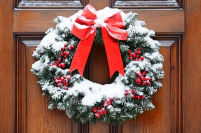 Snow Covered Christmas Wreath On Wooden Door