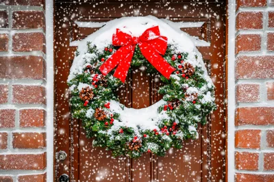 Snow Covered Christmas Wreath On A Wooden Door