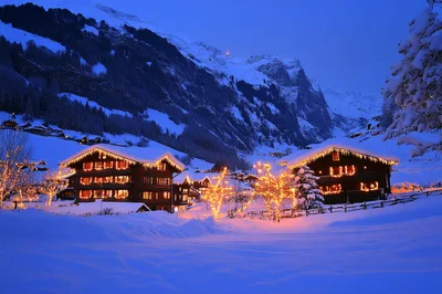 Illuminated Wooden Chalets In Snowy Swiss Alps Village