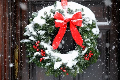 Snow Covered Christmas Wreath on Dark Wooden Door