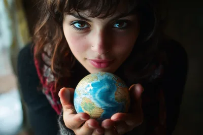 Young Woman Holding A Small Globe In Her Hands