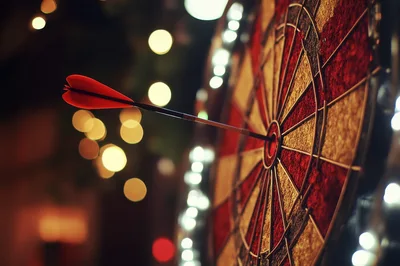 Red Dart Hitting The Bullseye On A Dartboard