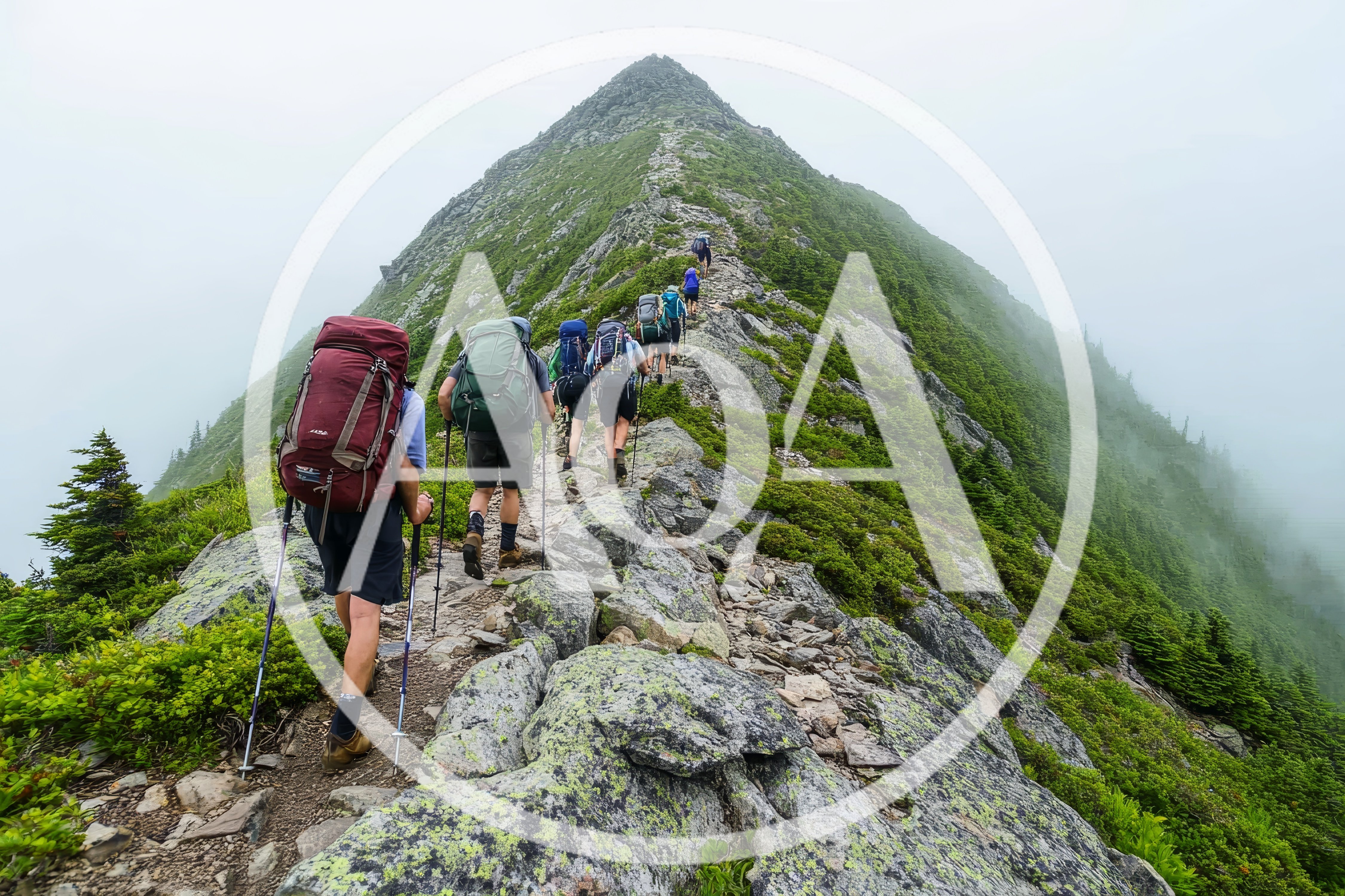 Group Of Hikers Trekking Up A Steep Mountain Ridge
